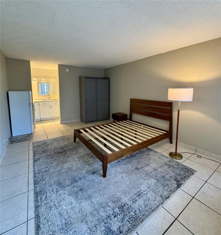 7900 South Orange Blossom Trail, Unit 2084 Orlando, FL 32809 - Photo 2 of 16 a bedroom with a bed and wooden floor