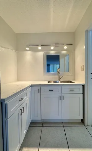 a spacious bathroom with a granite countertop sink and a mirror