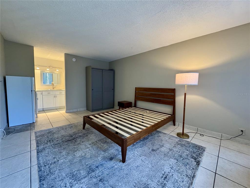 7900 South Orange Blossom Trail, Unit 2084 Orlando, FL 32809 - Photo 4 of 16 a bedroom with a bed and a lamp on table