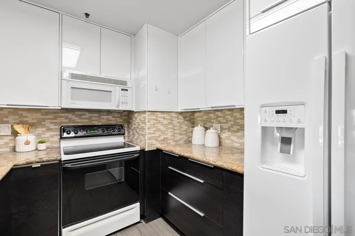5705 Friars Road, Unit 60 San Diego, CA 92110 - Photo 10 of 49 a kitchen with granite countertop cabinets stainless steel appliances and wooden floor