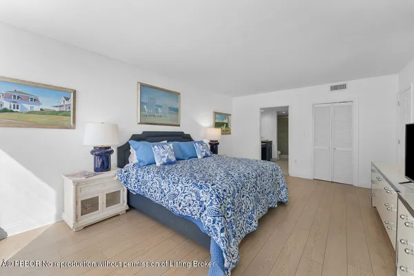 a bedroom with a bed and a flat tv screen on dresser