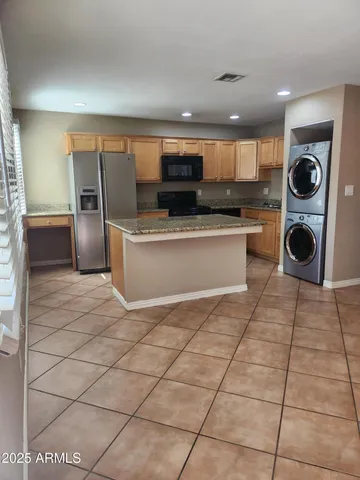 a kitchen with stainless steel appliances granite countertop a refrigerator a stove and a sink