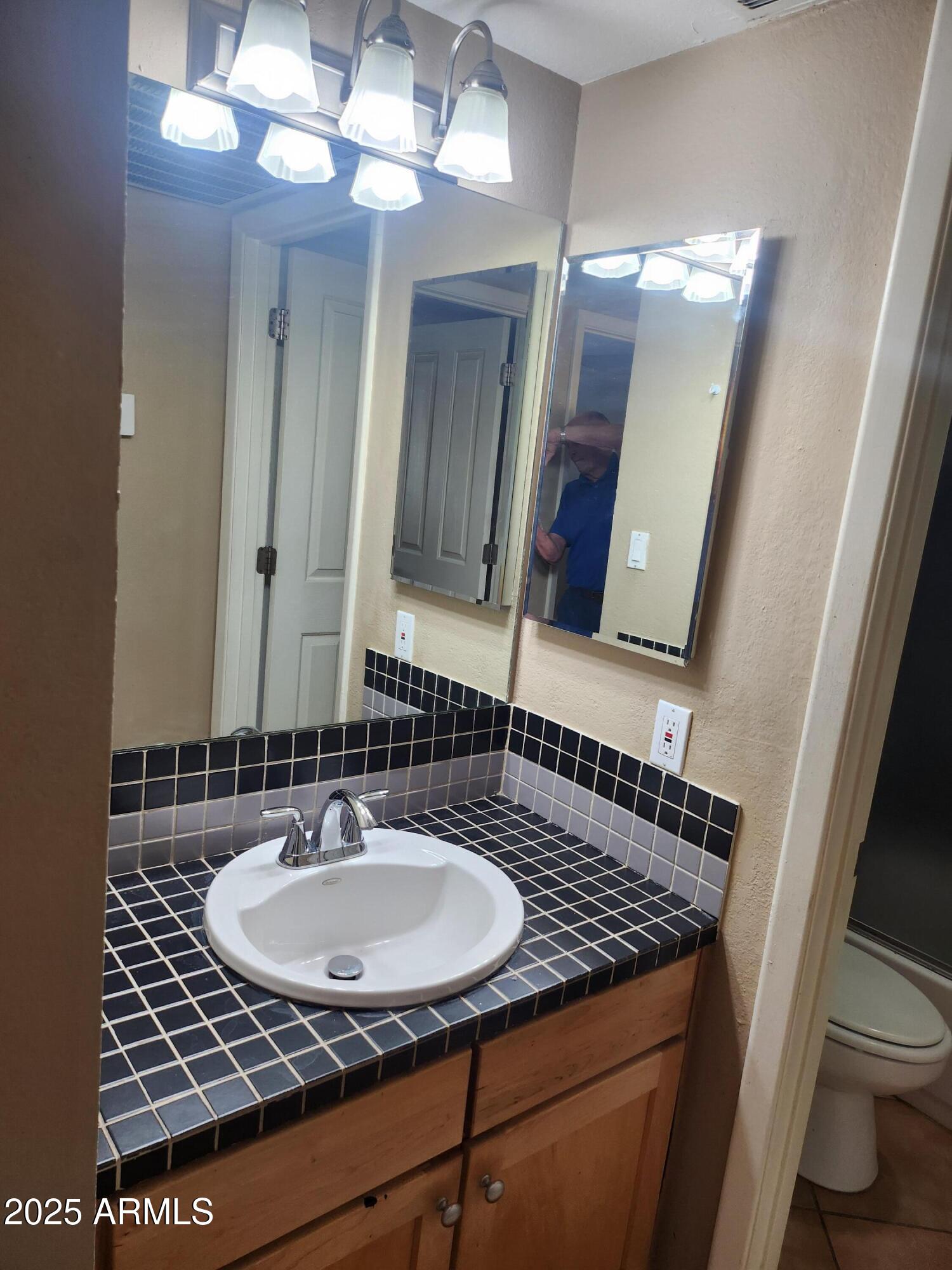 12440 North 20th Street, Unit 102 Phoenix, AZ 85022 - Photo 4 of 13 a bathroom with a sink and a mirror