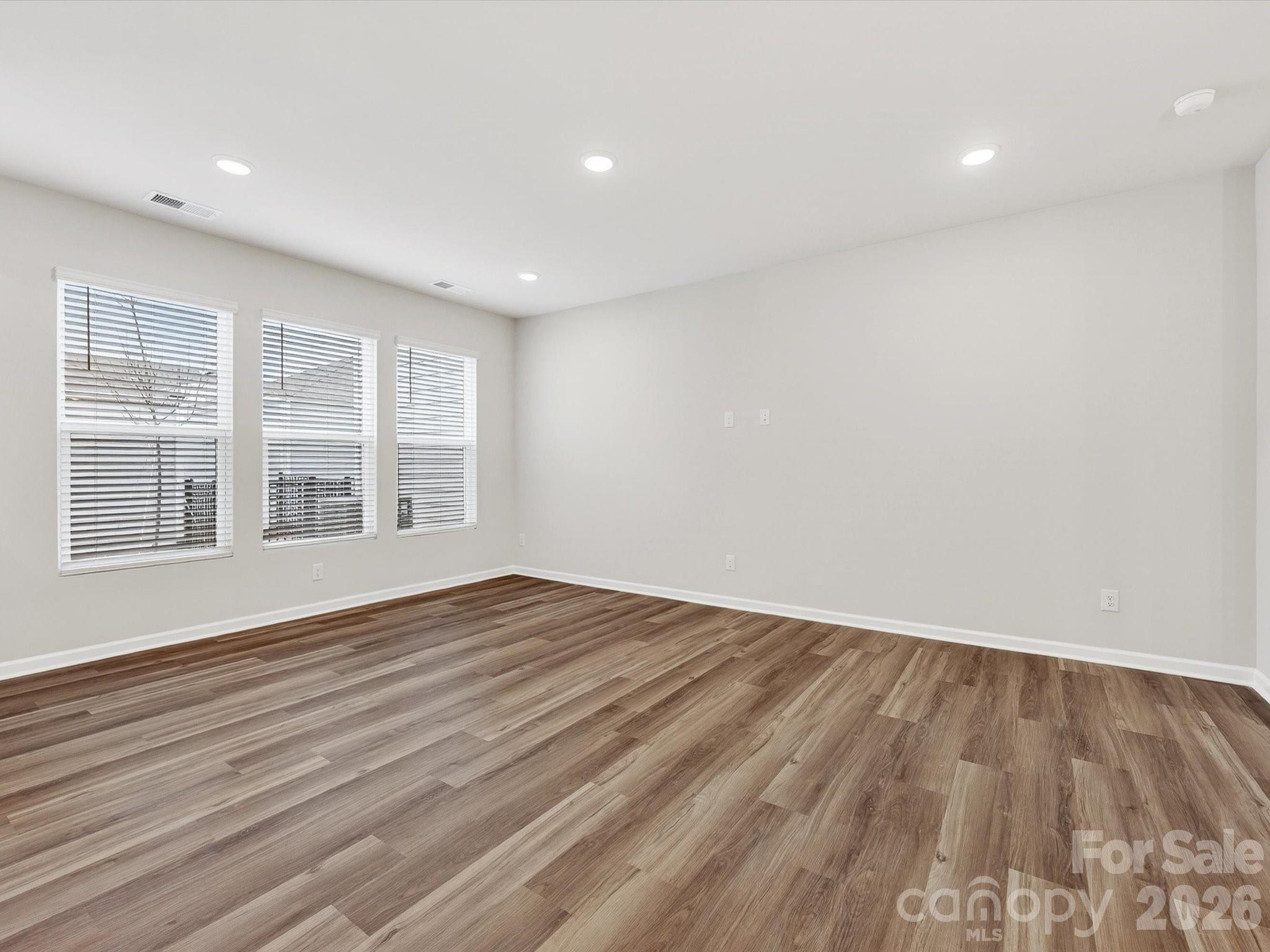 11441 Prosperity Church Road Huntersville, NC 28078 - Photo 13 of 32 a view of an empty room with wooden floor and windows