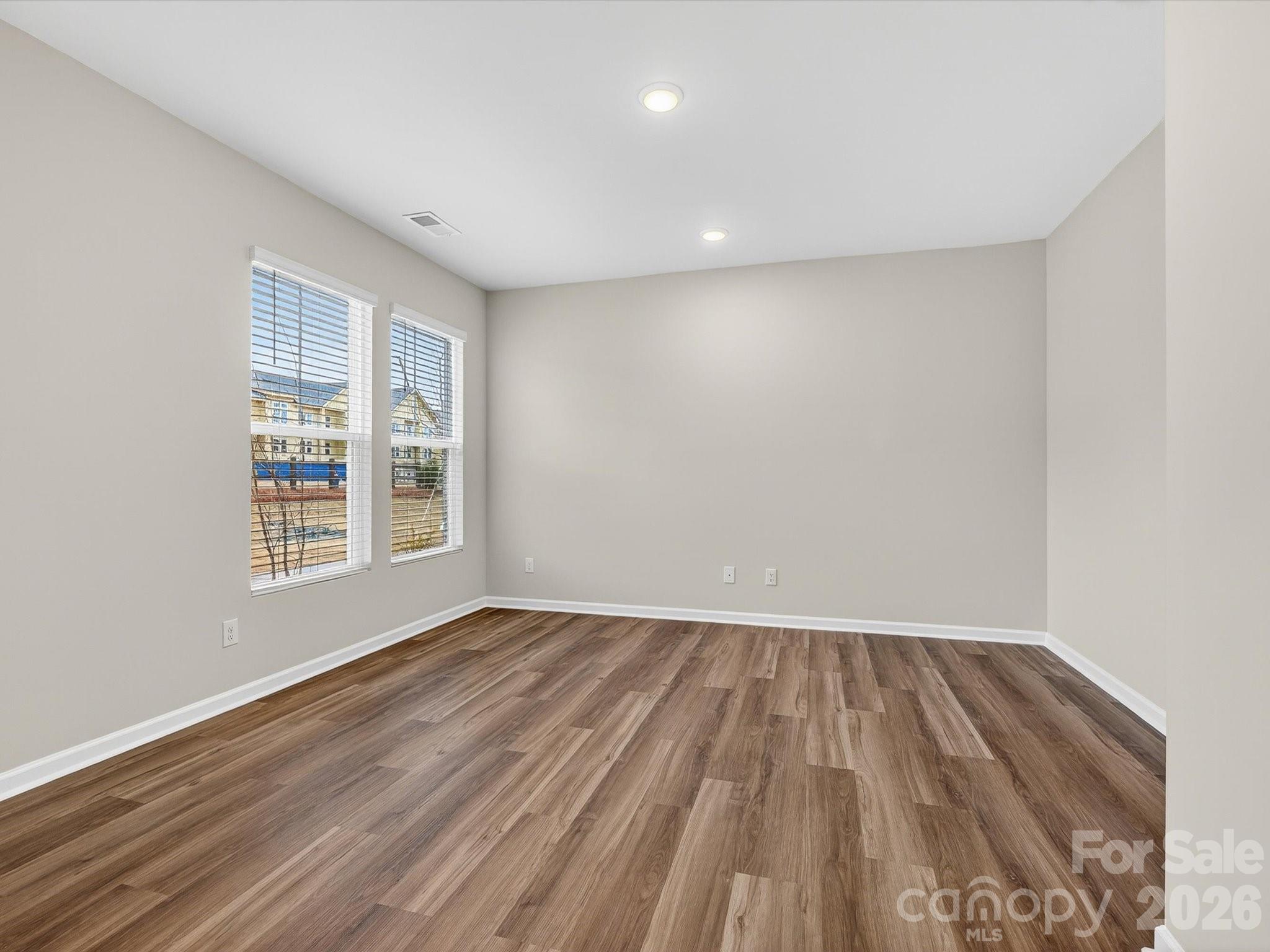 11441 Prosperity Church Road Huntersville, NC 28078 - Photo 5 of 32 a view of an empty room with wooden floor and a window