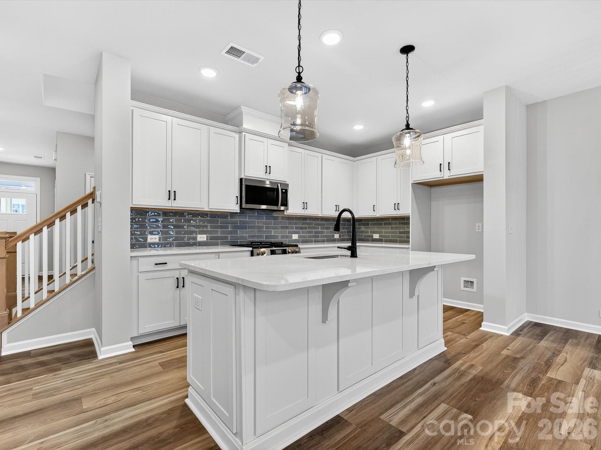 11441 Prosperity Church Road Huntersville, NC 28078 - Photo 8 of 32 a kitchen with kitchen island granite countertop a sink a counter space appliances and cabinets