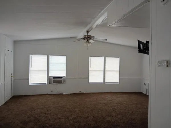 an empty room with a window and a ceiling fan