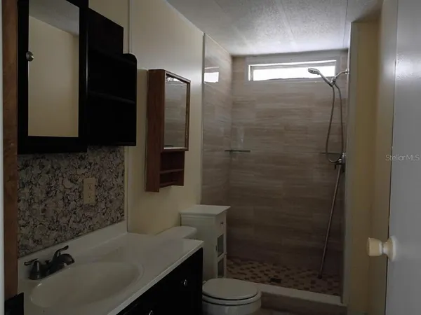 a bathroom with a sink toilet and shower