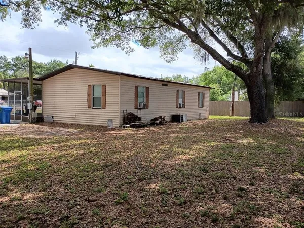 a backyard of a house with large trees and brick walls