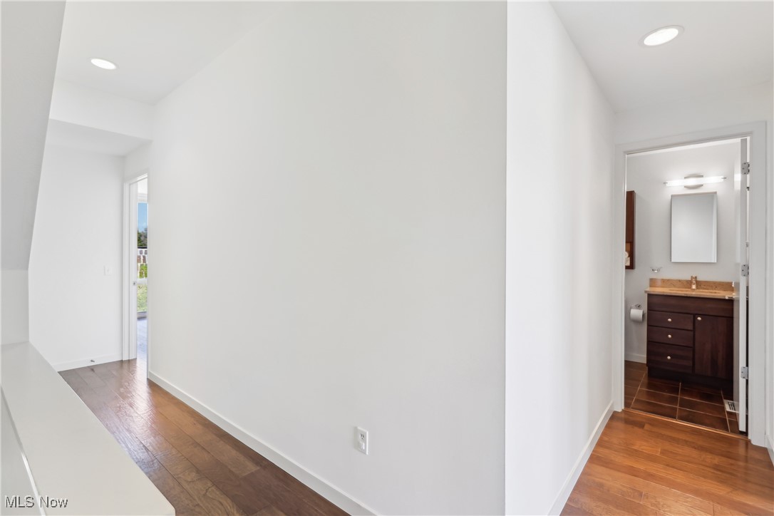 1852 Coltman Road Cleveland, OH 44106 - Photo 16 of 39 Hallway featuring baseboards, hardwood / wood-style flooring. Shared hall bath is seen to the right.