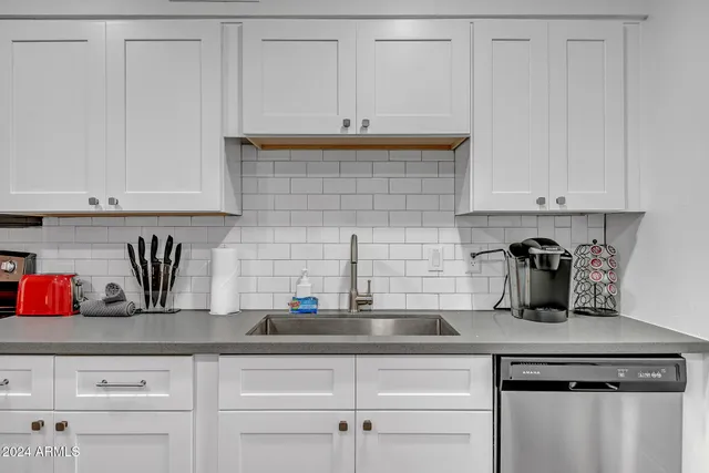 a kitchen with granite countertop white cabinets and a stove