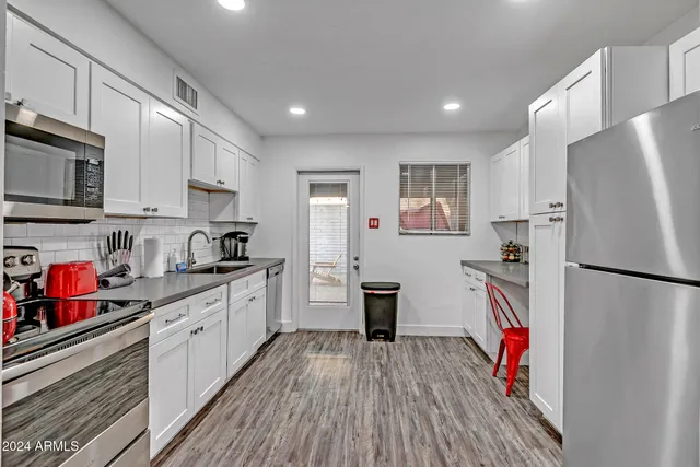 a kitchen with stainless steel appliances a refrigerator sink and microwave