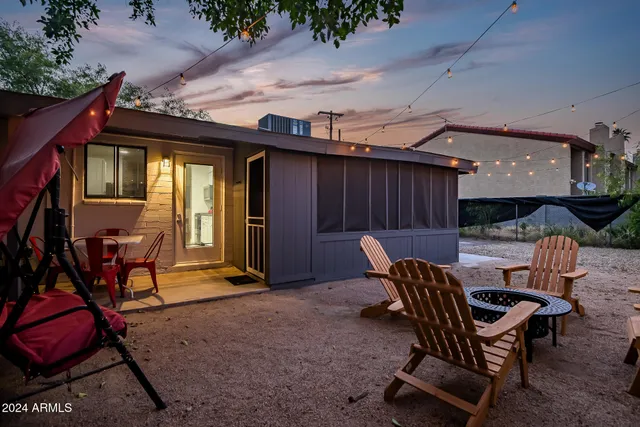 a backyard of a house with table and chairs