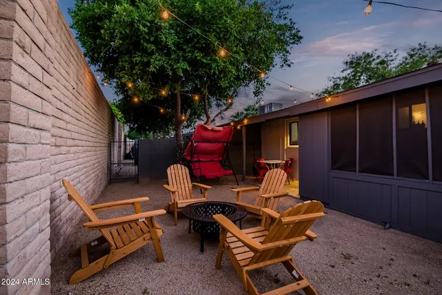a view of backyard with outdoor seating and wooden fence