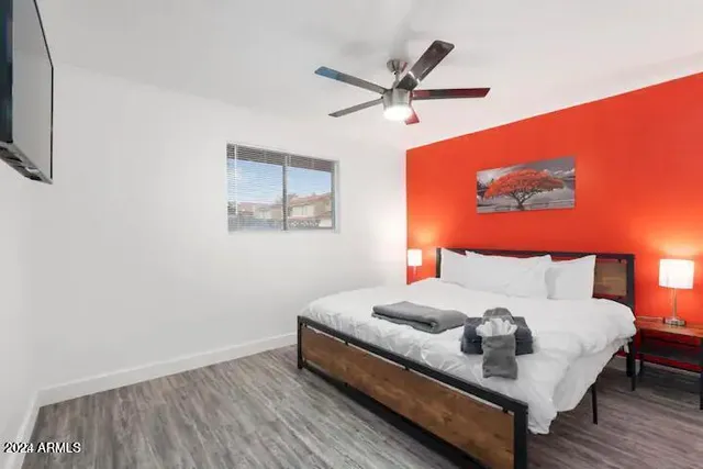 a bedroom with a bed and a painting on the wall