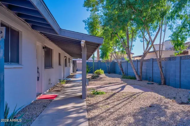 a backyard of a house with wooden fence and trees