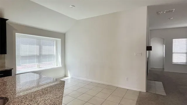 a kitchen with granite countertop wooden cabinets a refrigerator and a stove top oven