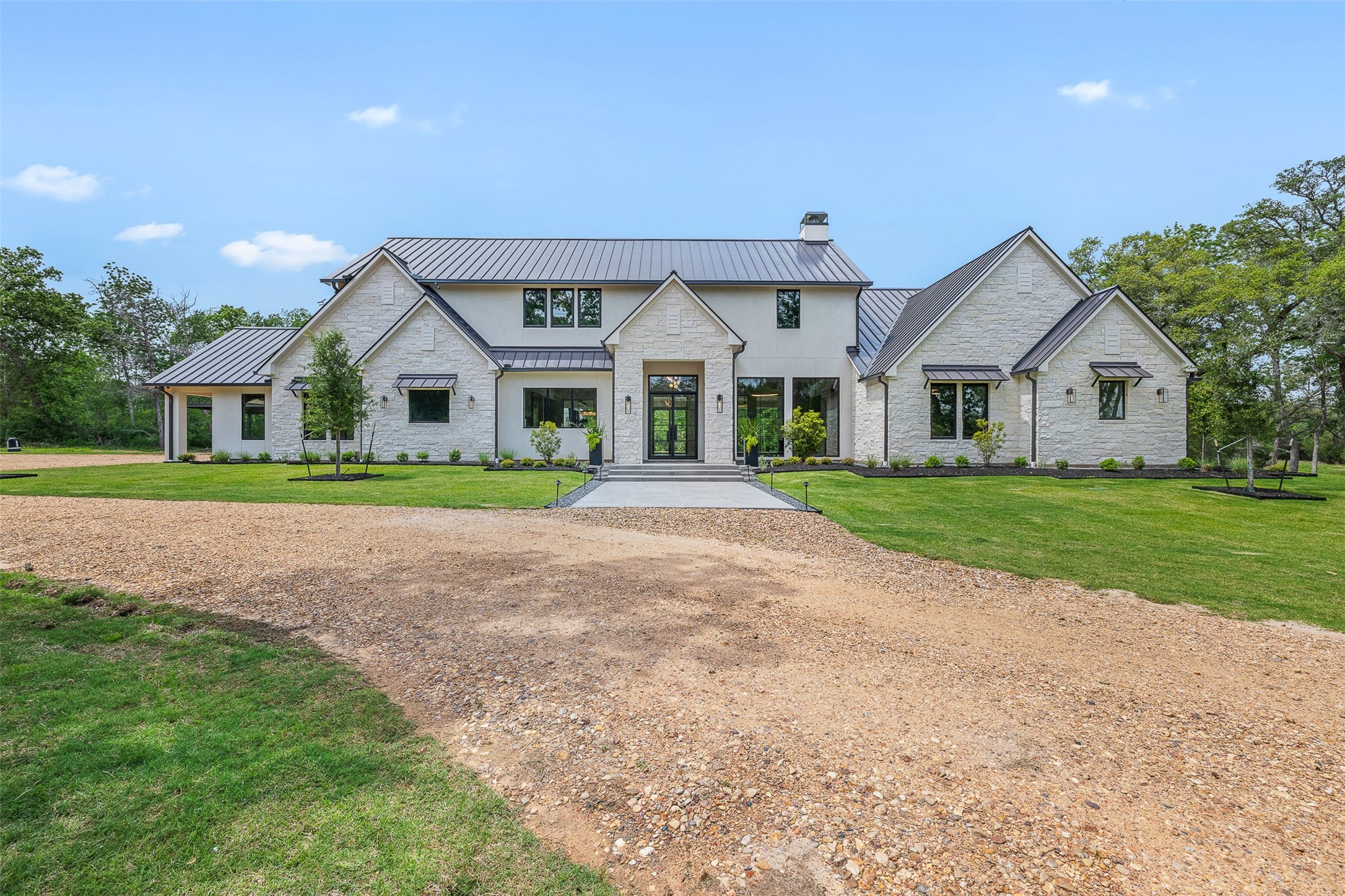 770 South Weyand Road Round Top, TX 78954 - Photo 1 of 50 a front view of a house with a yard and potted plants