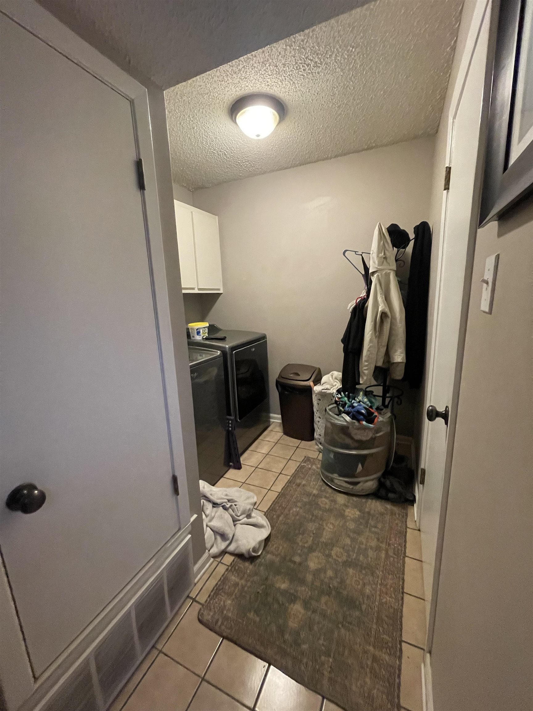 8469 Rothchild Road, Unit 33 Germantown, TN 38139 - Photo 15 of 25 Laundry room with cabinets, a textured ceiling, washer and clothes dryer, and light tile patterned flooring
