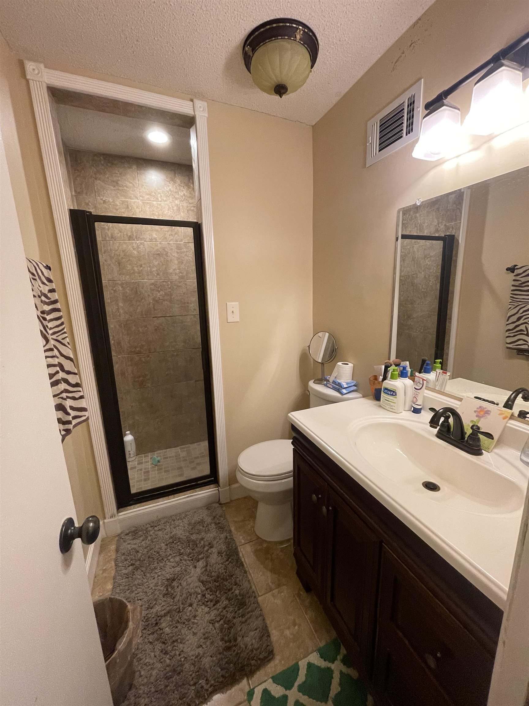 8469 Rothchild Road, Unit 33 Germantown, TN 38139 - Photo 20 of 25 Bathroom featuring vanity, a shower with door, tile patterned flooring, toilet, and a textured ceiling