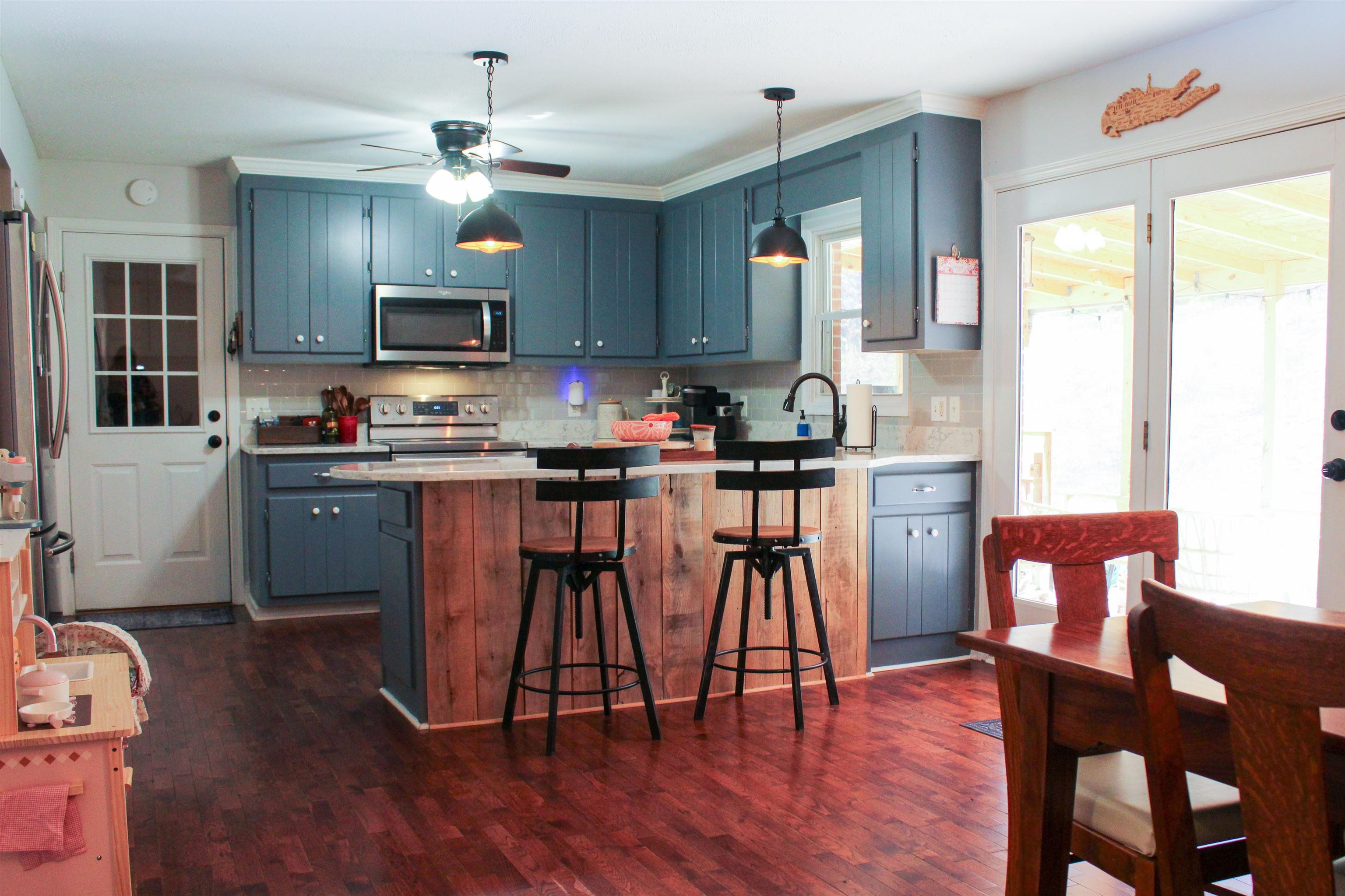 169 Calf Mountain Road Waynesboro, VA 22980 - Photo 15 of 74 a kitchen with stainless steel appliances granite countertop a stove a sink dishwasher a dining table and chairs with wooden floor