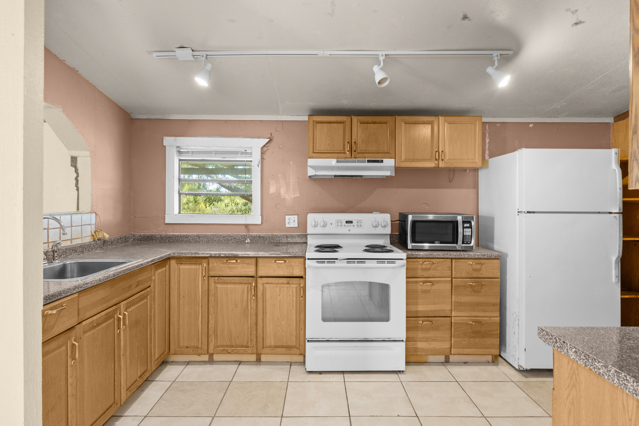 147 Community Center Road Rosanky, TX 78953 - Photo 10 of 33 Kitchen featuring white appliances, track lighting, and light tile patterned floors