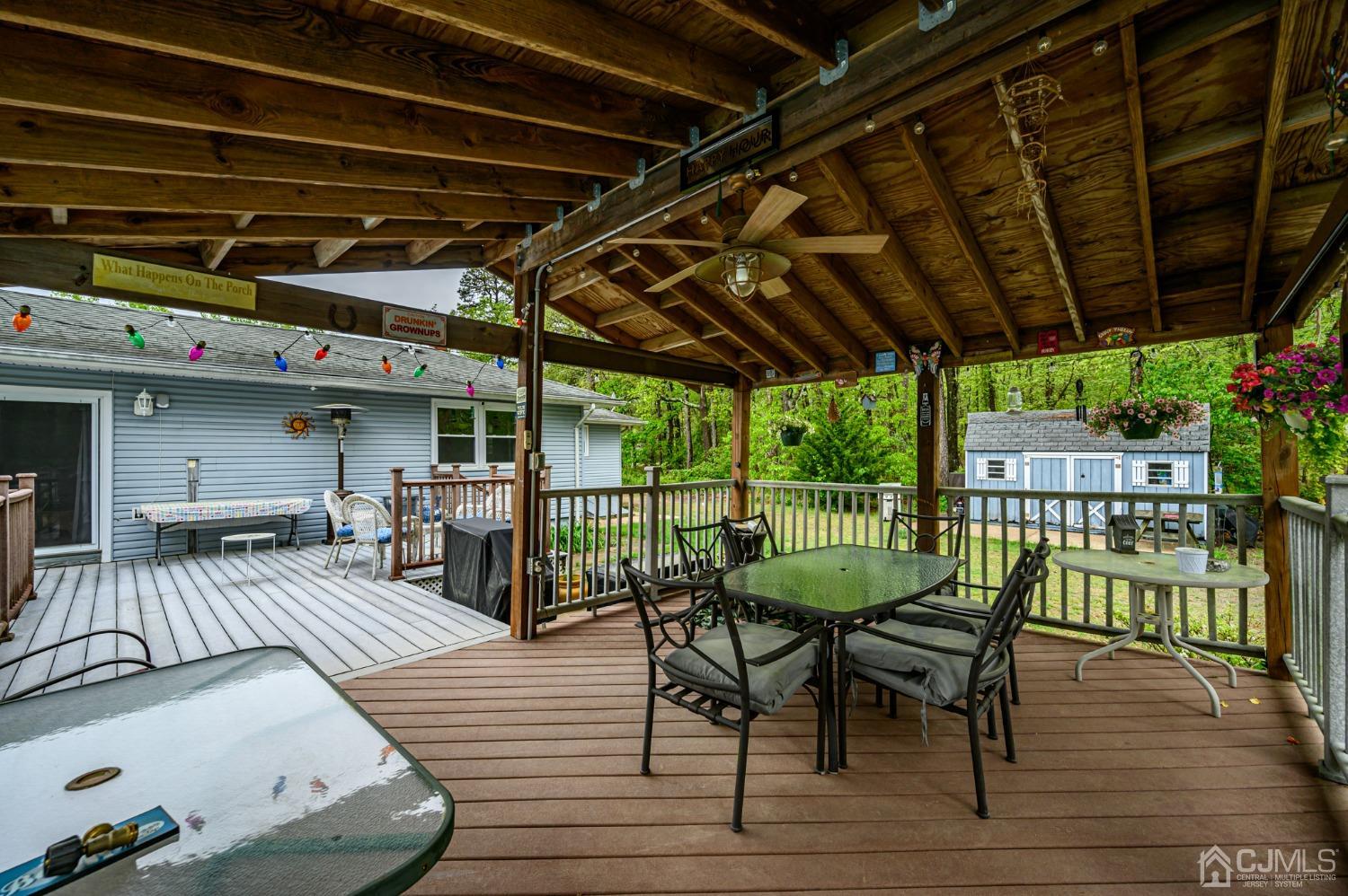 439 Cassville Road Jackson, NJ 08527 - Photo 38 of 45 a view of a roof deck with table and chairs a barbeque with wooden floor