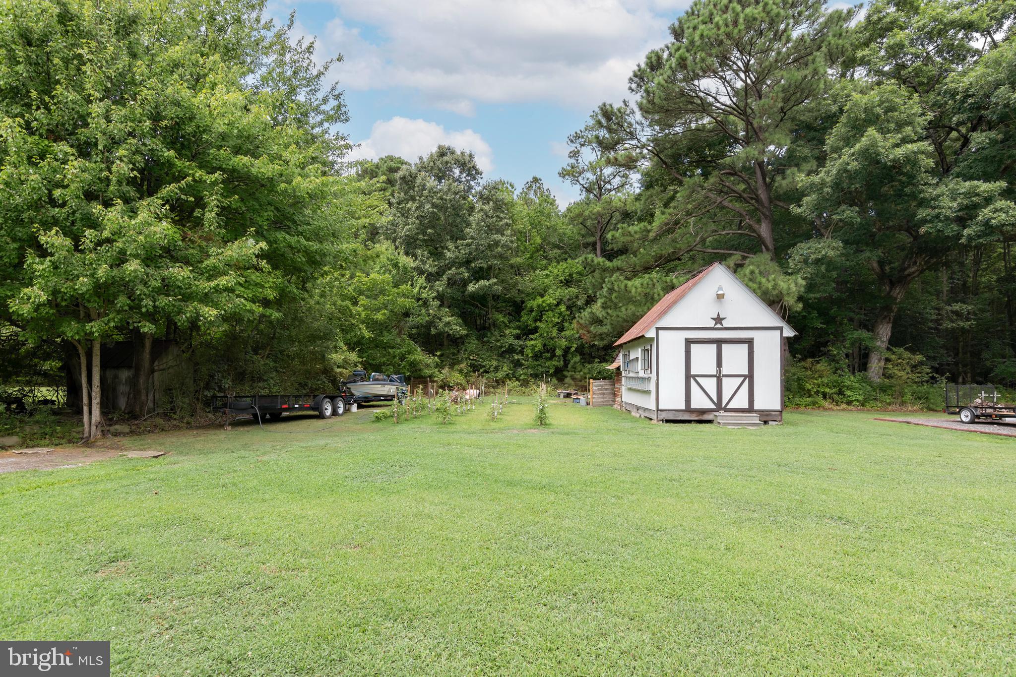 5614 Casson Neck Cambridge, MD 21613 - Photo 12 of 38 a yellow house with a big yard and large trees