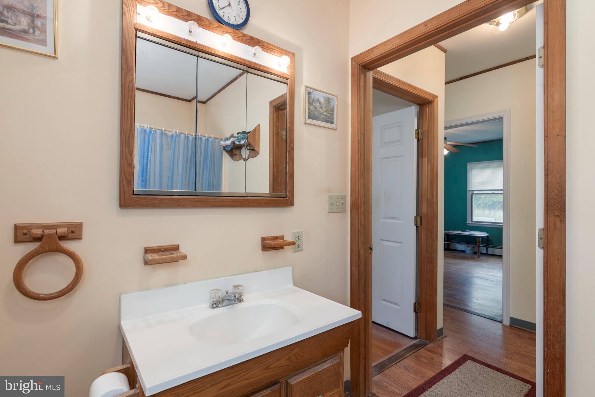5614 Casson Neck Cambridge, MD 21613 - Photo 26 of 38 a bathroom with a sink a mirror and a shower
