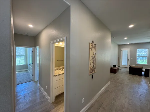 a view of a hallway with wooden floor and stairs