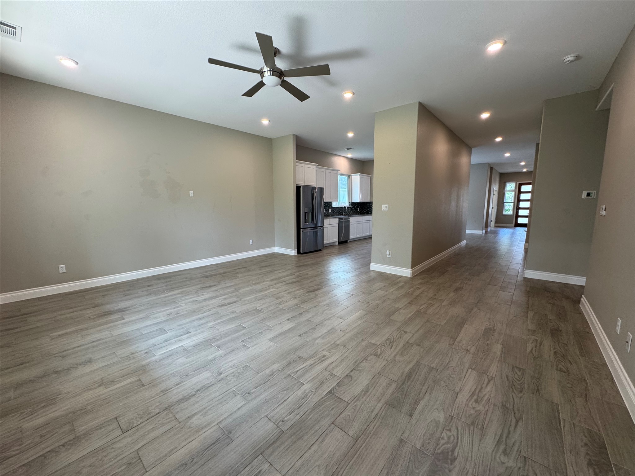 109 Mokulua Bastrop, TX 78602 - Photo 19 of 32 an empty room with wooden floor ceiling fan and windows