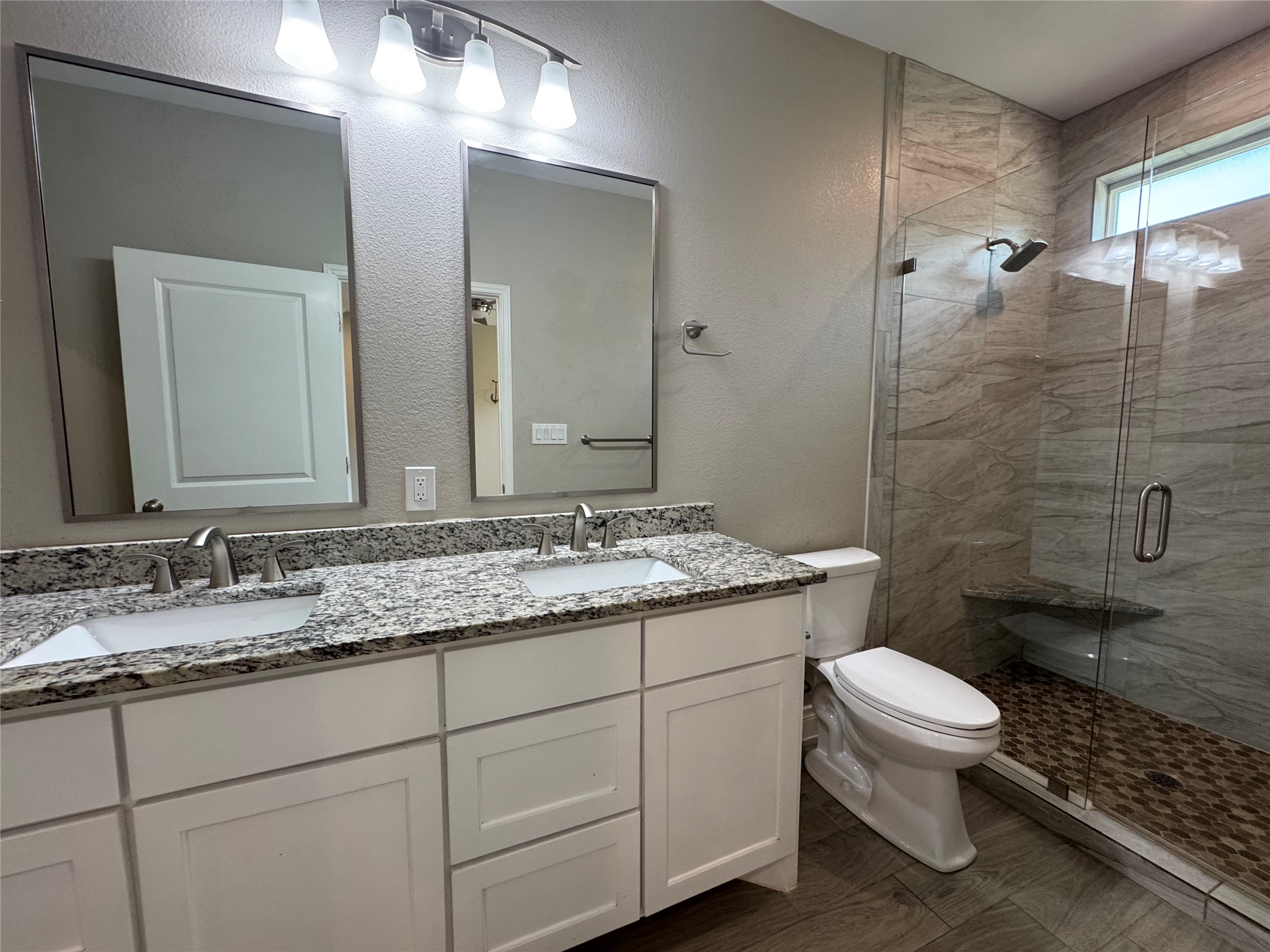 109 Mokulua Bastrop, TX 78602 - Photo 21 of 32 a bathroom with a granite countertop toilet a sink and a mirror