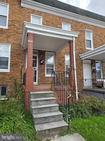 a view of a house with large windows and plants