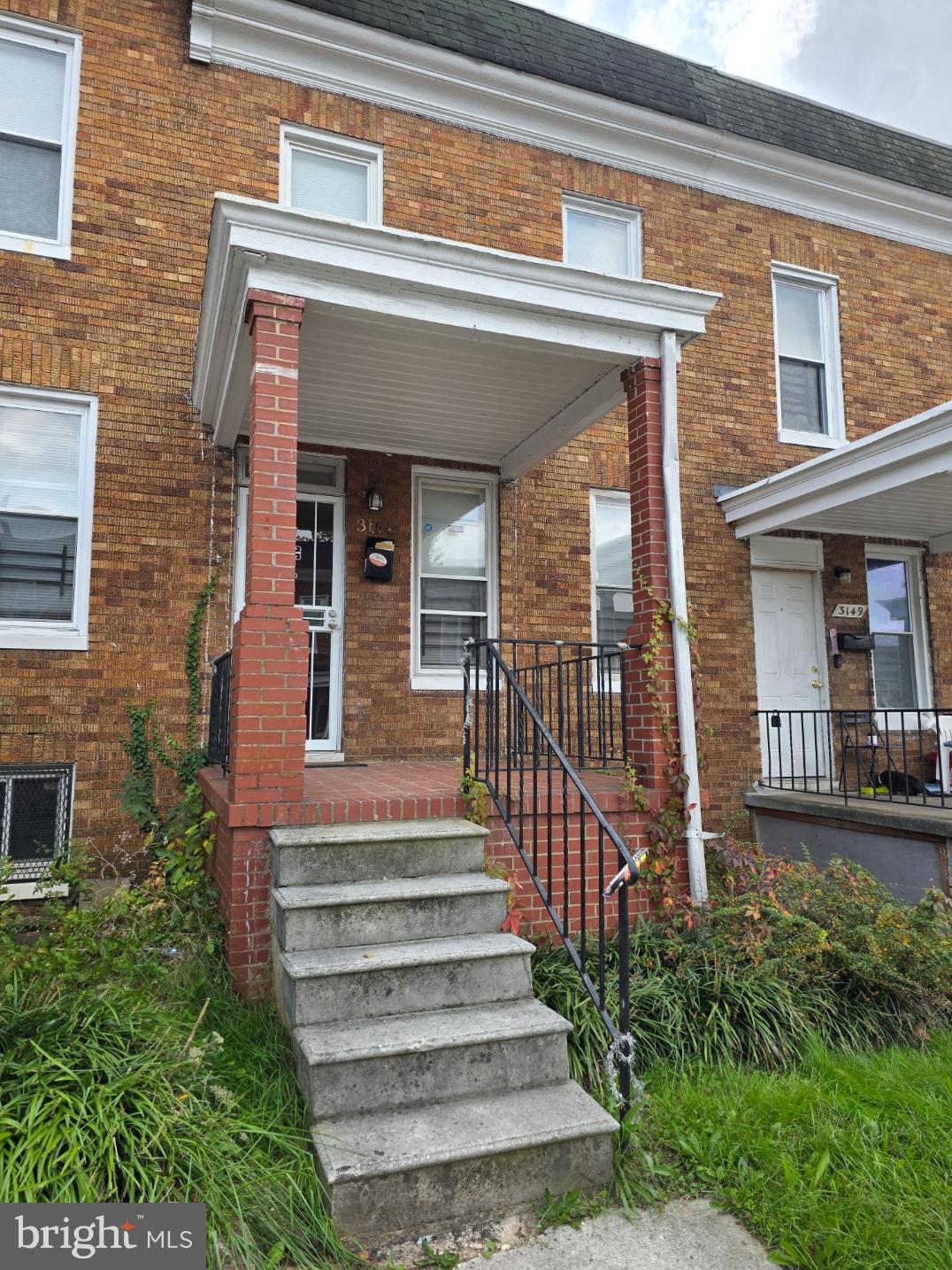 a view of a house with large windows and plants