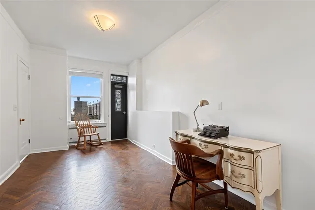 a view of a workspace with furniture and a window