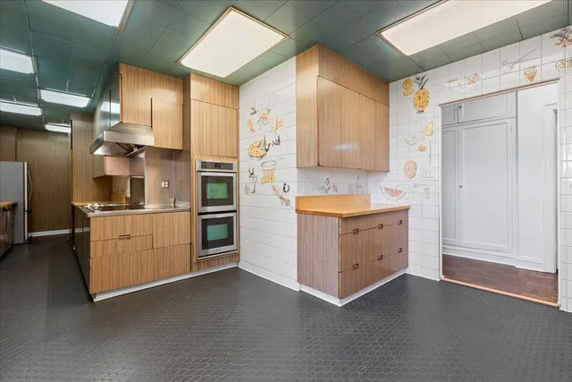 a kitchen with a refrigerator stove and white cabinets