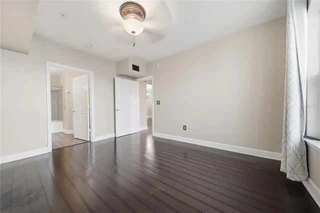 an empty room with wooden floor and window