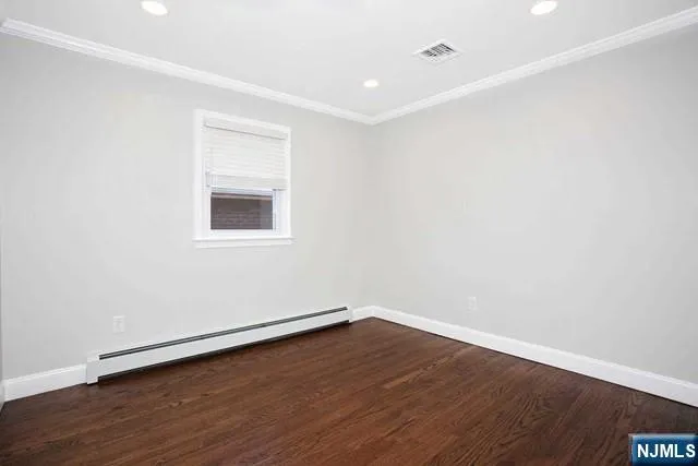 a view of a room with wooden floor and white walls
