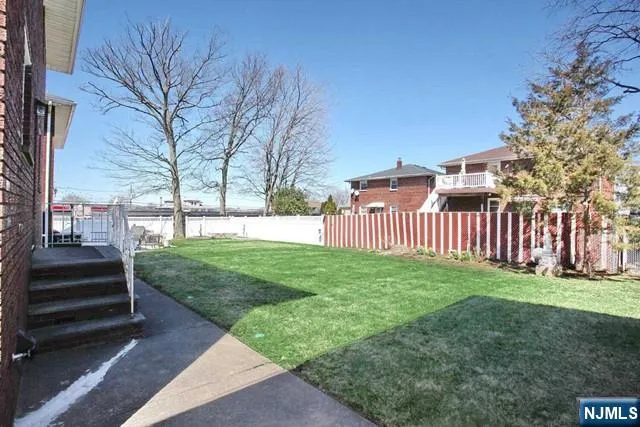 a view of a yard with wooden fence
