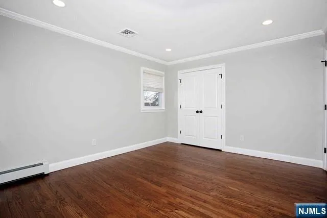 a view of an empty room with wooden floor