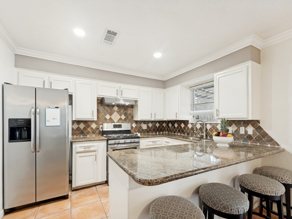 124 Bluebird Lane Pasadena, TX 77502 - Photo 4 of 25 a kitchen with stainless steel appliances granite countertop a sink stove and refrigerator