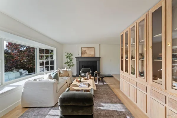 a living room with furniture fireplace and a large window