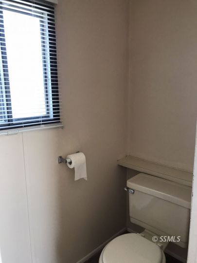 4233 West Ward Avenue Ridgecrest, CA 93555 - Photo 11 of 19 a white toilet sitting next to a window