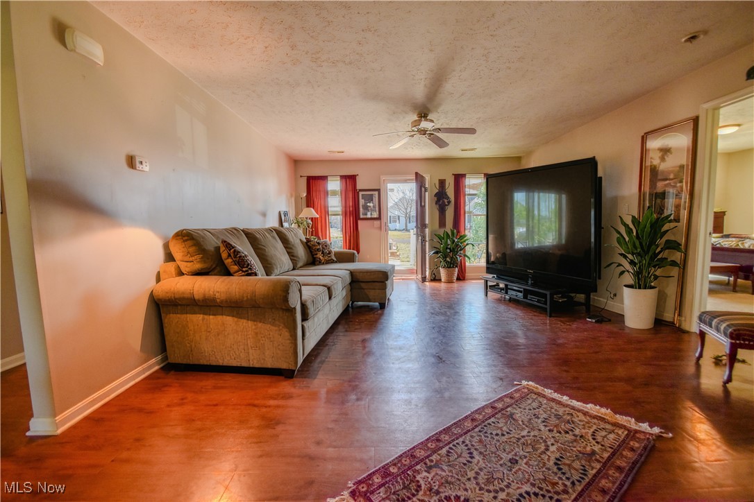 643 Wood Ridge Road Geneva, OH 44041 - Photo 13 of 24 Living area with a textured ceiling, ceiling fan, wood finished floors, and baseboards