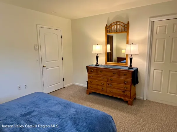 a room with a bed and a lamp on dresser