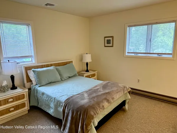 a bedroom with a bed and windows