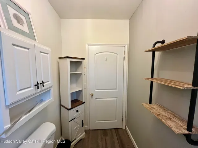a small white house with a white roof and table and chairs next to yard
