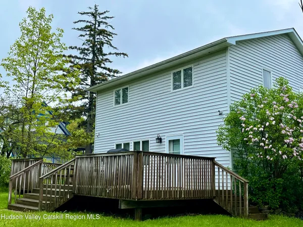 a view of a house with a yard and potted plants