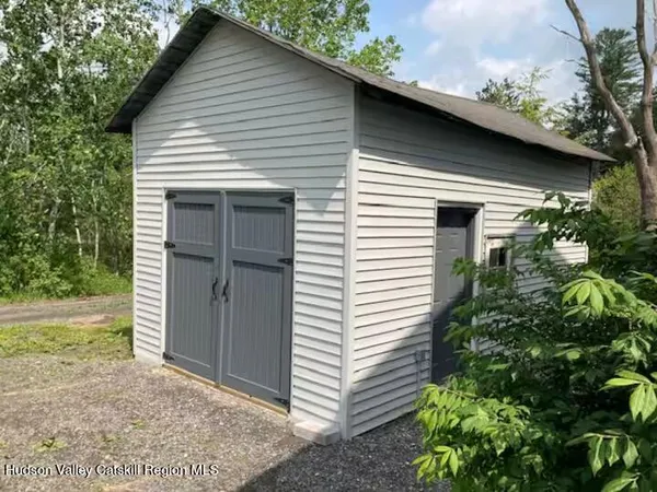 a small white house with a white roof and table and chairs next to yard