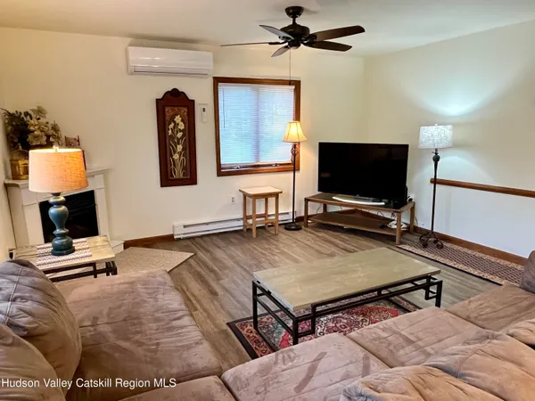 a living room with hard wood floor and a flat screen tv